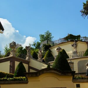 Ornate staircase with statues and manicured bushes
